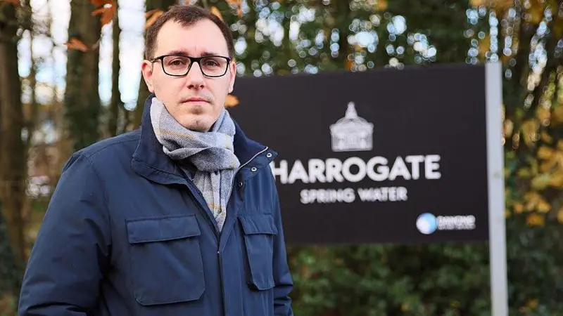 Tom Gordon MP in front of a Harrogate Spring Water sign